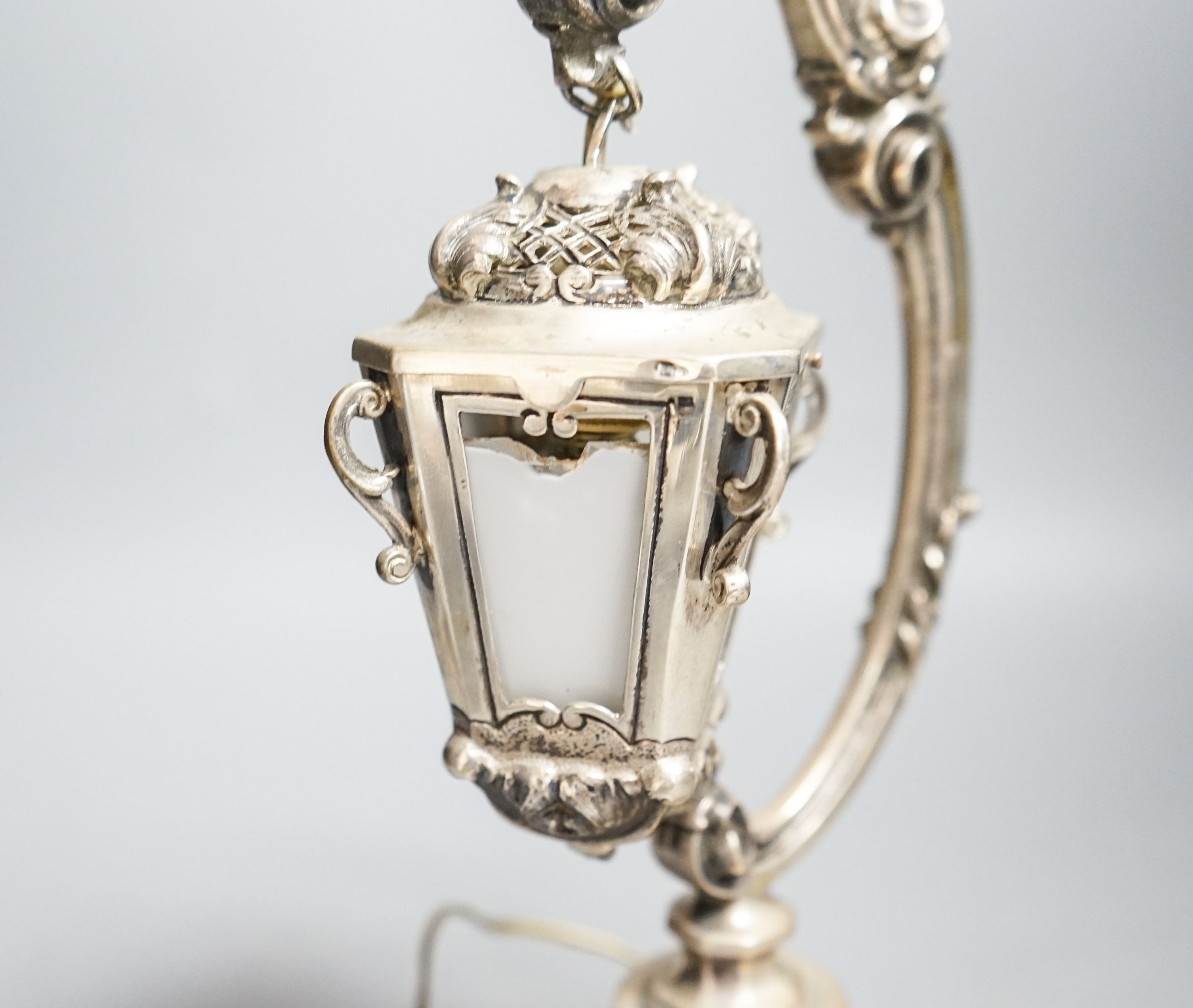 A Portuguese white metal table lamp modelled as a hanging lantern, height 28.1cm.